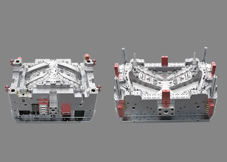 Two halves of a double-colour lamp mould with red guide components